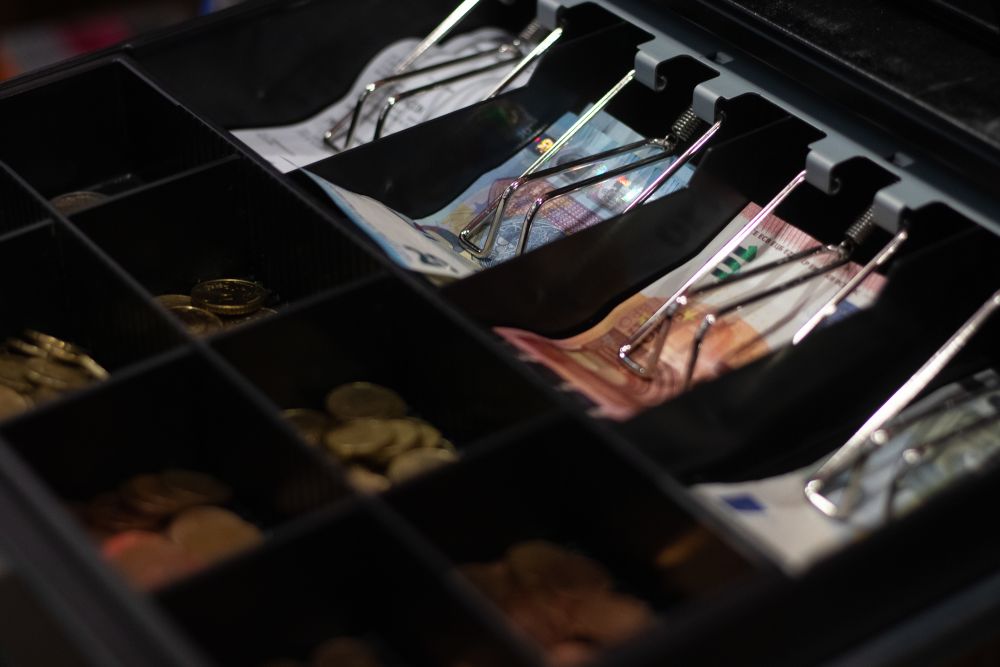 Offene Kasse mit unterschiedlichen Euro Scheinen und Münzen