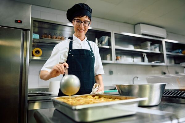 Köchin steht in der Küche und bereitet essen vor
