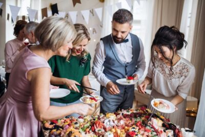 Gäste einer Hochzeitsfeier füllen ihre Teller mit Essen