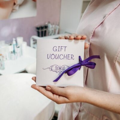 Beauty Salon Besitzerin präsentiert das Kuvert ihres Geschenkgutscheins